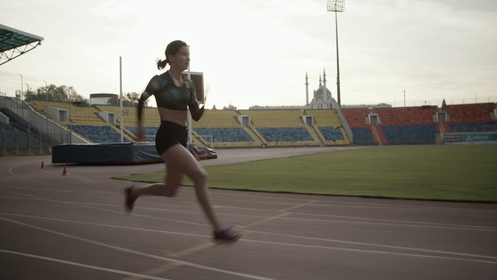 A woman sprinter driving forward on the track